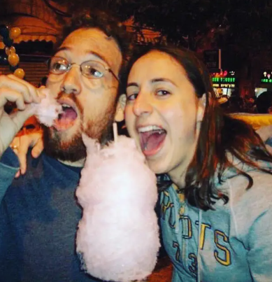 Couple sharing cotton candy at night