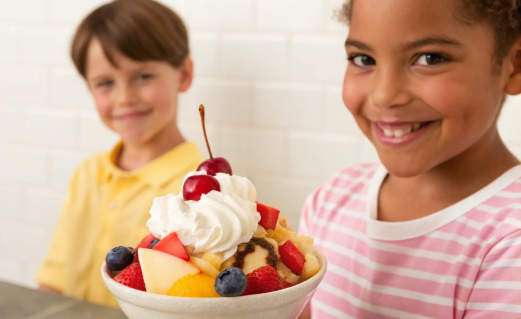 Child with dessert and whipped cream