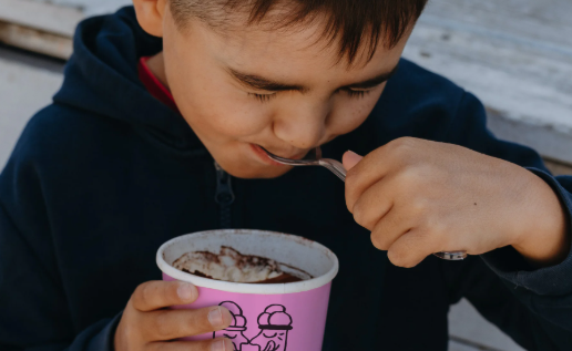 Child with chocolate on face enjoying dessert